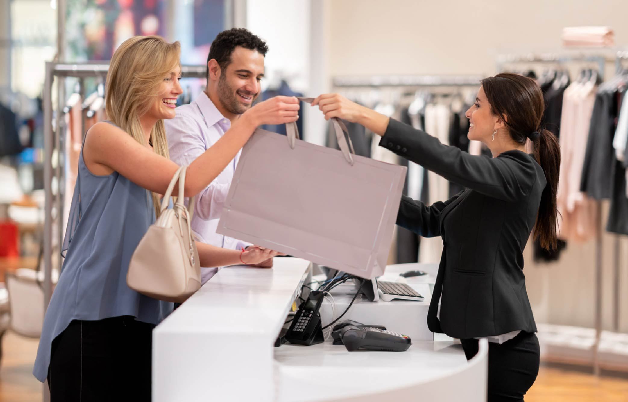 The Power of Clienteling: 4 Reasons Why Retailers Should Adopt the Technique | PointofSale Retail clerk handing shopper bag Retail customer service tips 01 1